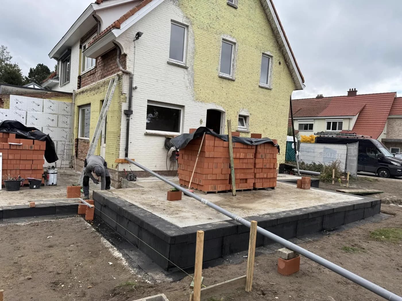 Isolatieplaten die op een gevel onder stellingen worden geplaatst.